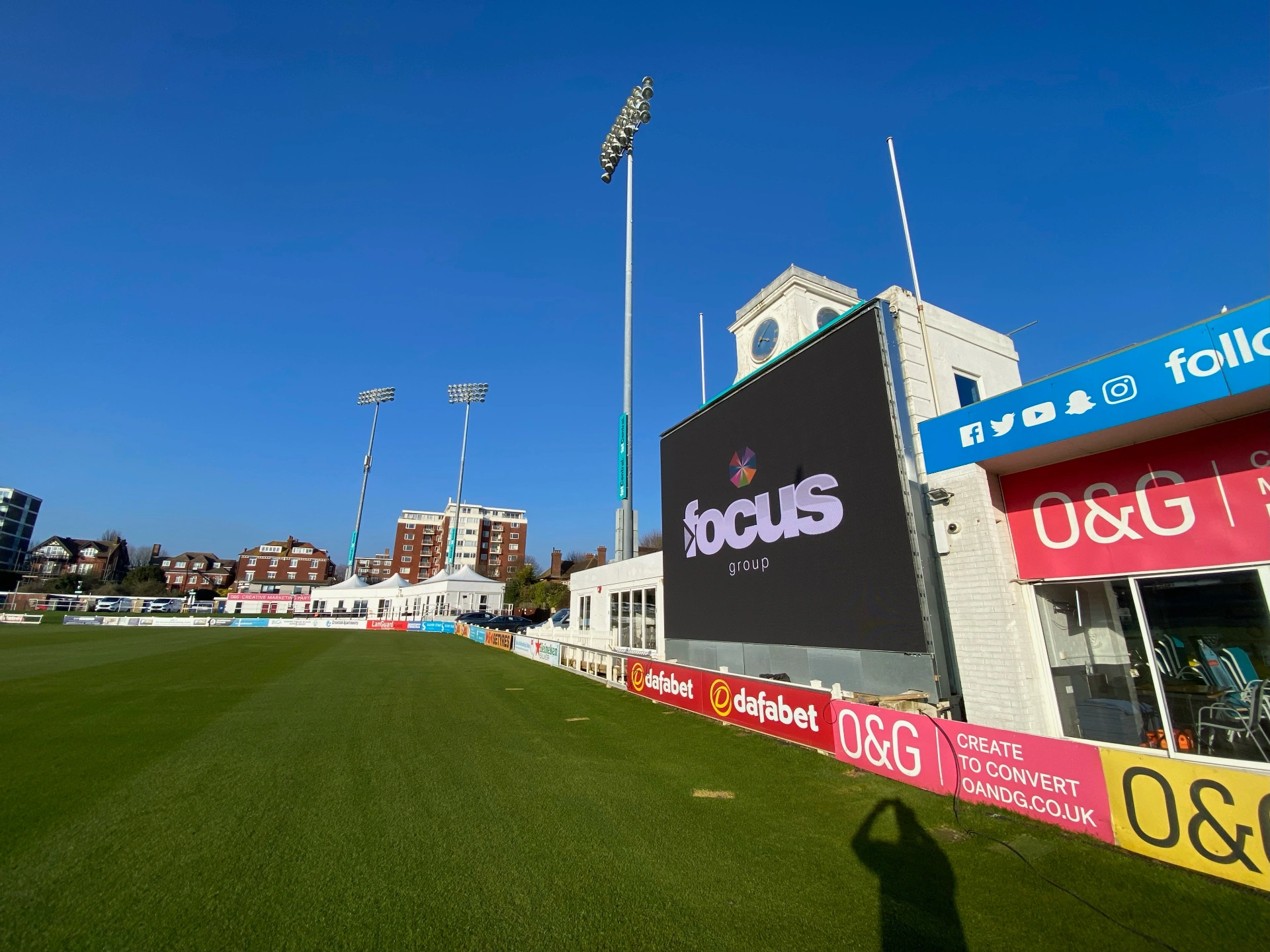 Brighton Cricket — outdoor LED scoreboard installed above pavilion at Sussex County Cricket Ground, viewed across boundary from cricket outfield