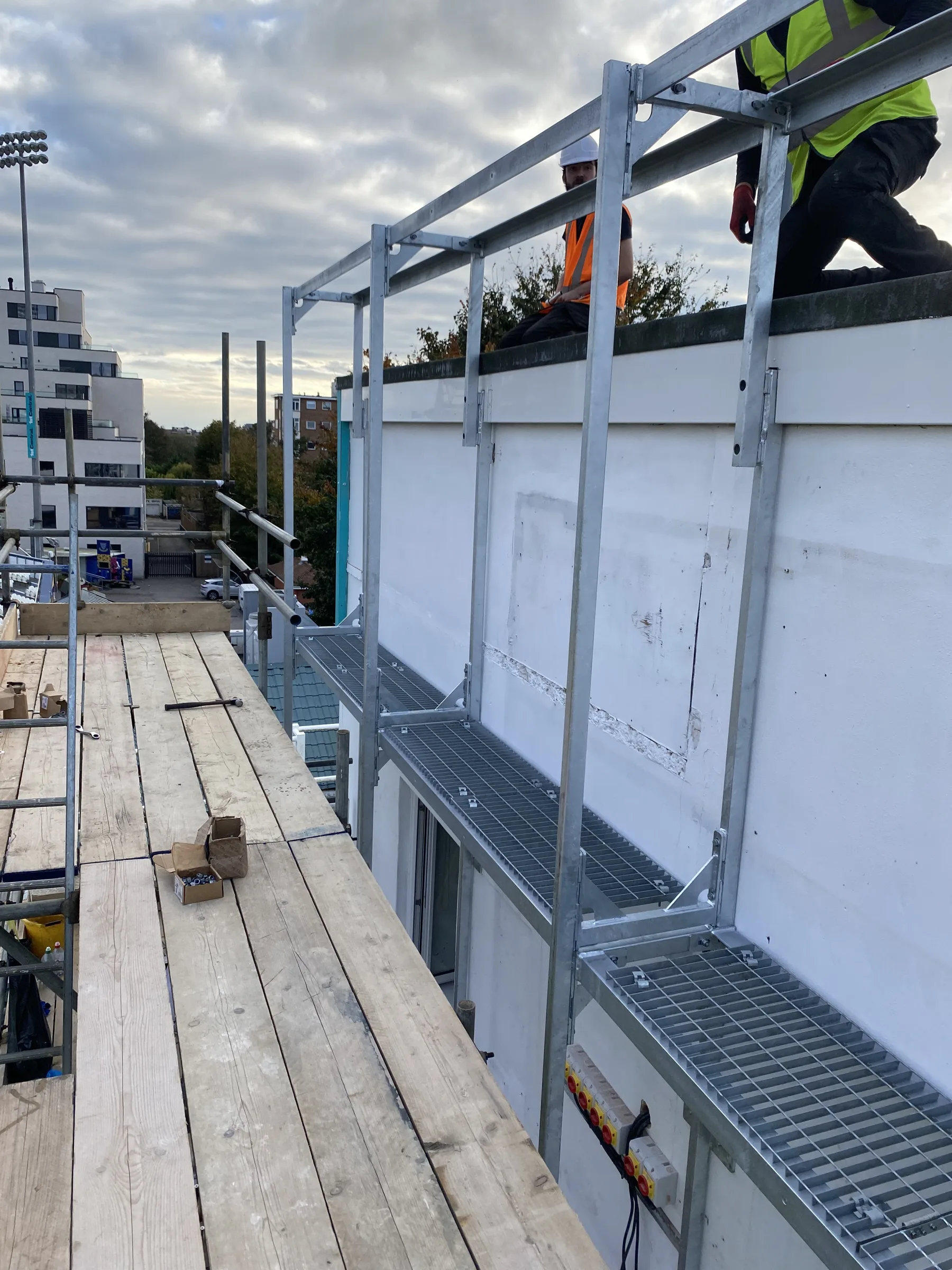 Brighton Cricket — galvanised maintenance access platform being installed onto pavilion facade with Westlind crew working on rooftop
