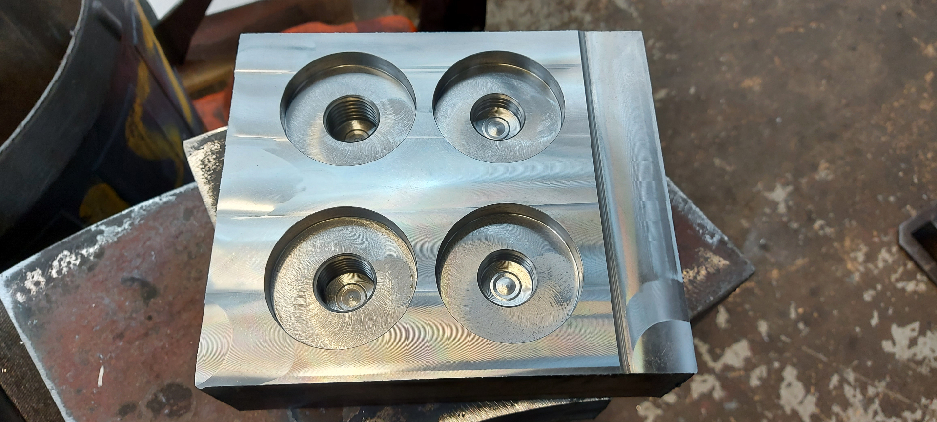 CNC — aluminium block with four counter-bored seats and tapped centres, brushed finish from face mill