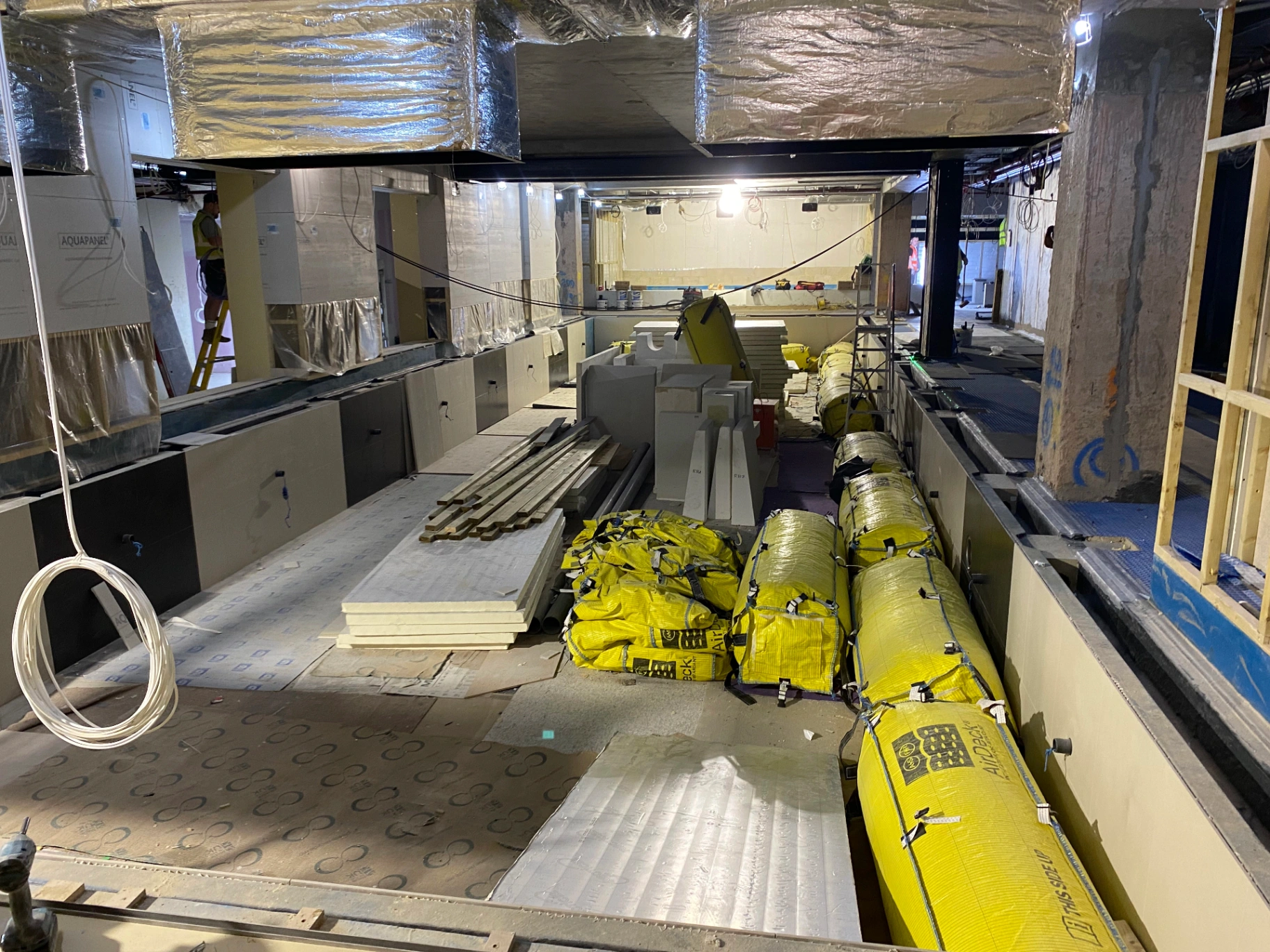 Spa — pool tank mid-fit-out with engineered MEP services, acoustic ductwork and waterproof substrate prepared for stone cladding