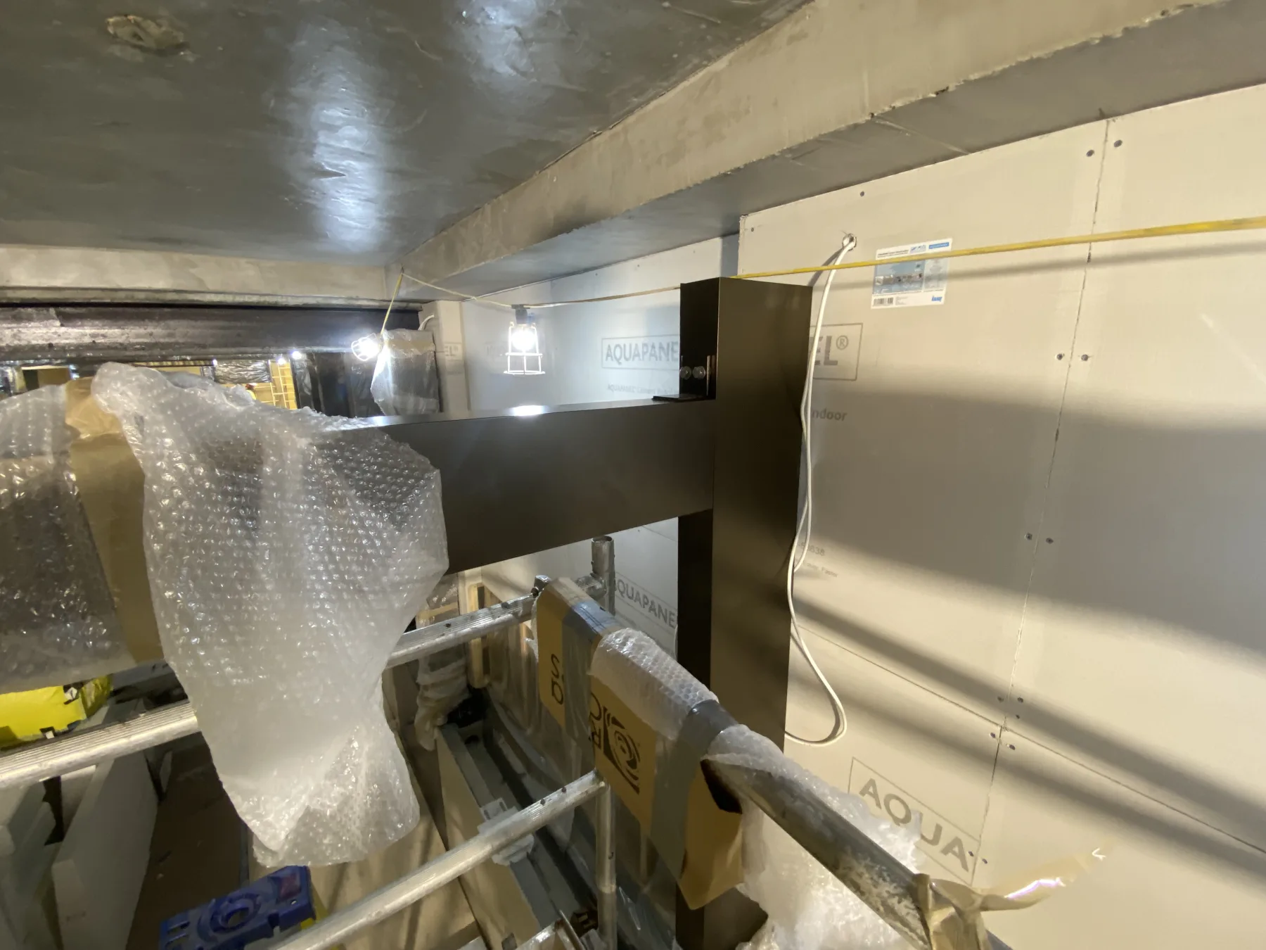 Third Space — close-up of aluminium bracket and beam connection detail tying frame back to the concrete substrate