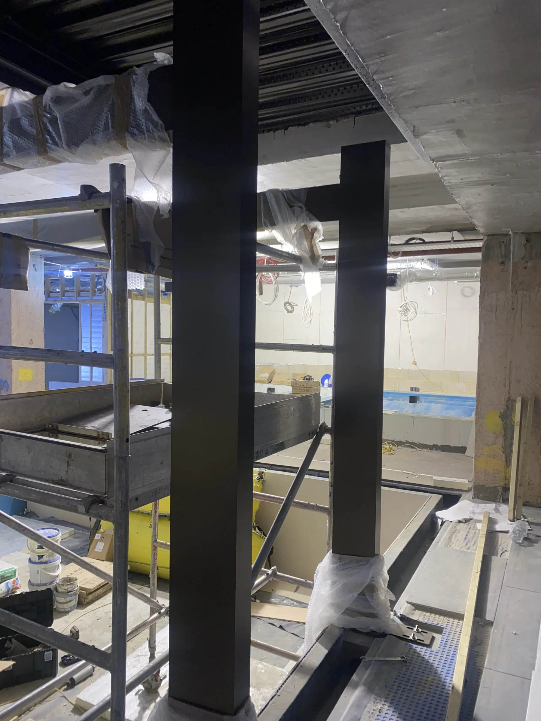 Third Space — paint-finished aluminium structural columns and beams installed above the pool tank during fit-out